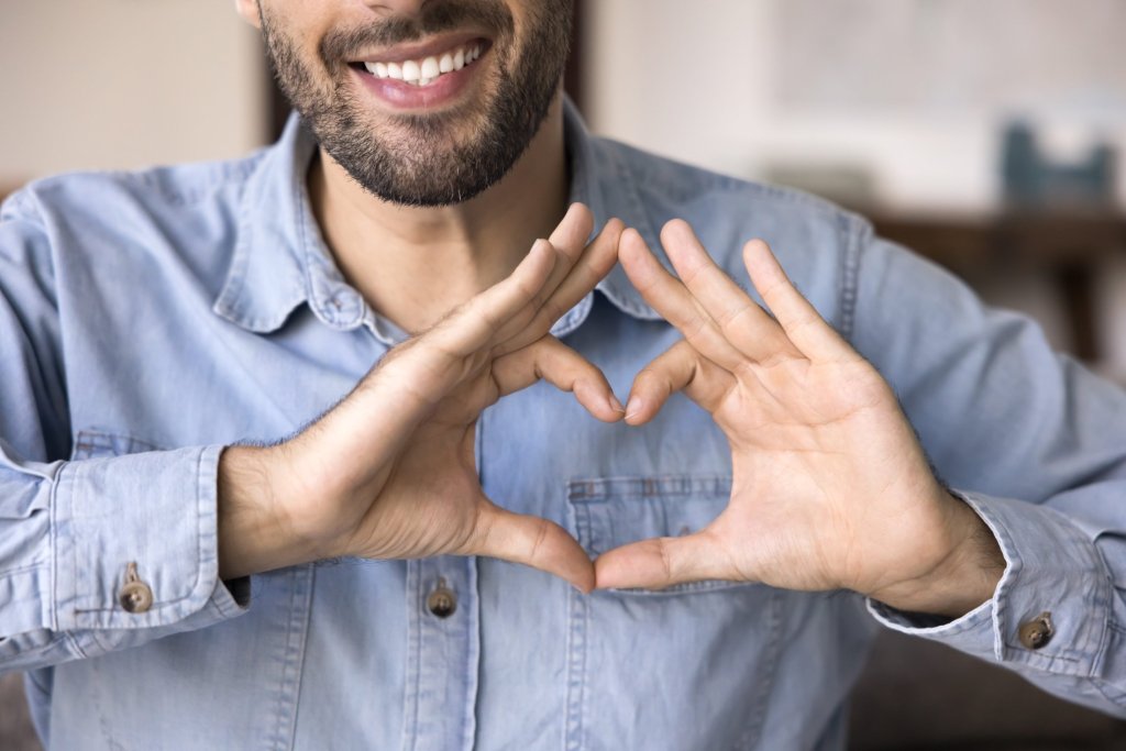 man making heart hand symbol